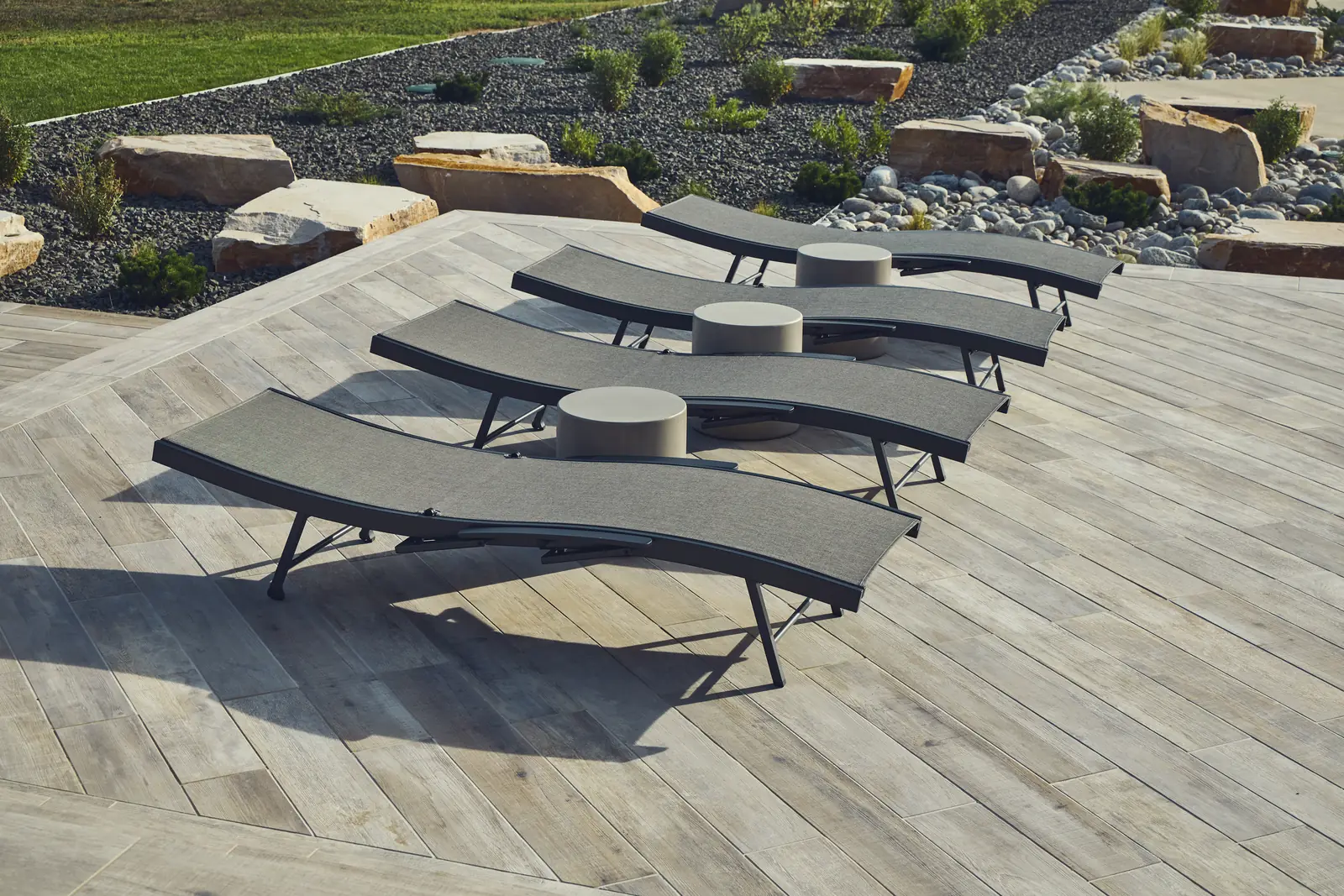 Row of chaise lounges on a wood-look porcelain paver pool deck, Johnson Estate, Colorado