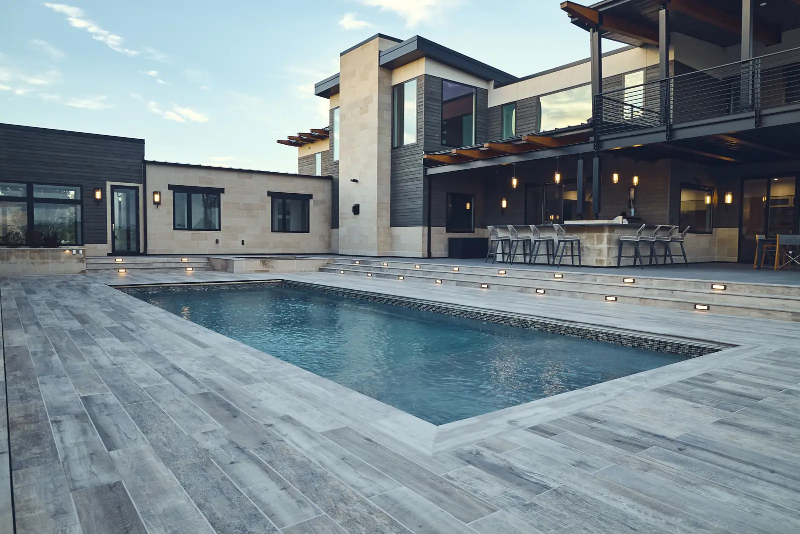 Wide view of the pool, modern home, and pergola-covered outdoor bar, Johnson Estate, Colorado