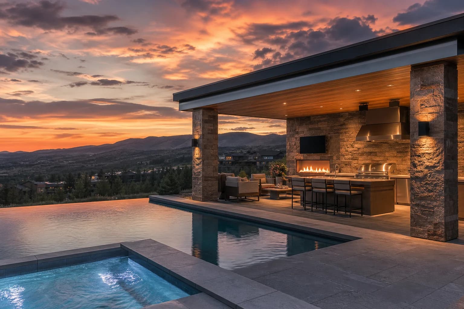 Stone pavilion with outdoor kitchen, fireplace wall, and infinity pool edge at Colorado sunset